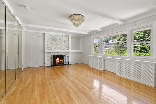 202 W Main St, Mount Kisco, NY 10549 - unfurnished living room featuring hardwood / wood-style floors, radiator heating unit, beam ceiling, and a lit fireplace