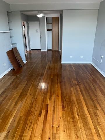 unfurnished room with dark wood-type flooring, baseboards, and ceiling fan