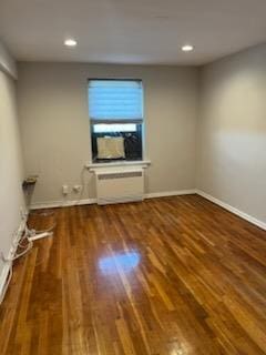 unfurnished room featuring wood finished floors, baseboards, and recessed lighting