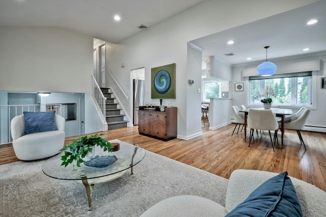 living room with stairway, wood finished floors, baseboard heating, recessed lighting, and crown molding
