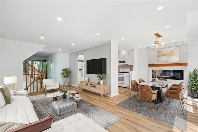 1601 Pondcrest Ln, White Plains, NY 10607 - living room with light wood-style flooring, stairway, recessed lighting, ornamental molding, and a glass covered fireplace