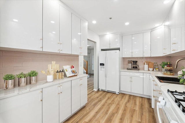1601 Pondcrest Ln, White Plains, NY 10607 - kitchen featuring white refrigerator with ice dispenser, a sink, white cabinetry, backsplash, and recessed lighting