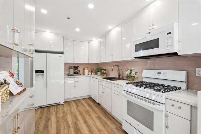 1601 Pondcrest Ln, White Plains, NY 10607 - kitchen with white appliances, a sink, light wood-style floors, white cabinetry, and recessed lighting