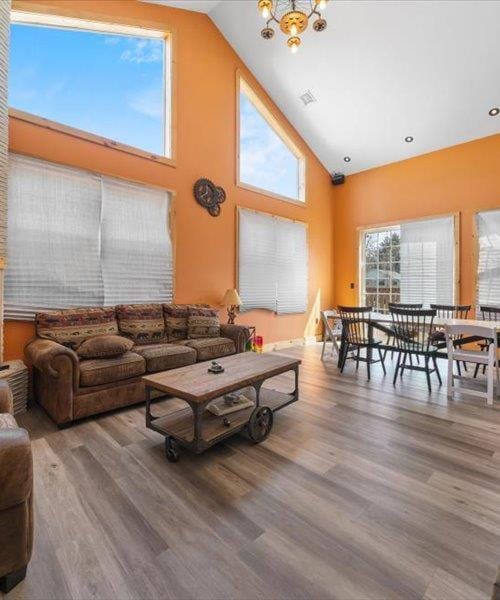 living area featuring wood finished floors, a chandelier, and high vaulted ceiling