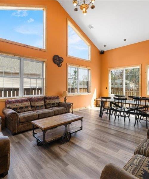 living room featuring a chandelier, wood finished floors, and high vaulted ceiling