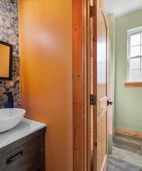 bathroom with vanity, wood finished floors, and baseboards