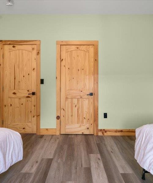 unfurnished bedroom with wood finished floors and baseboards