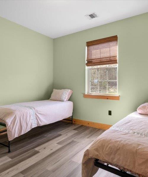 bedroom featuring wood finished floors and baseboards