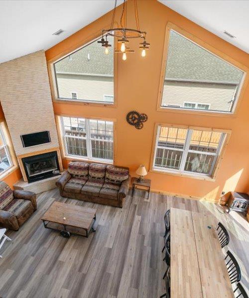 living room with a towering ceiling, wood finished floors, and a fireplace