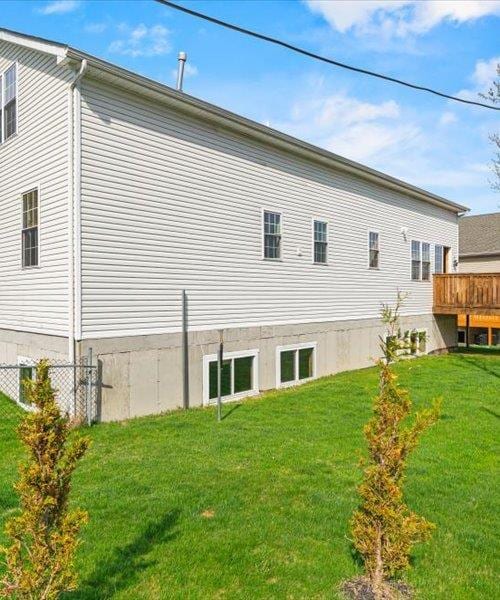 back of property with a yard and a deck