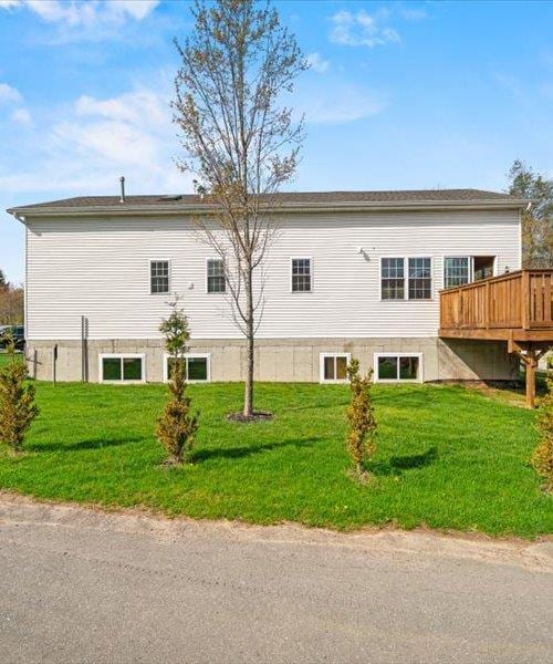 view of property exterior featuring a yard and a wooden deck