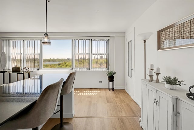 dining space with light wood finished floors and baseboards