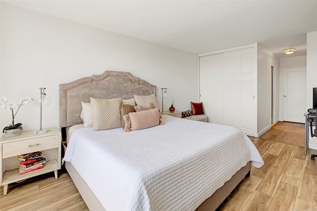 bedroom featuring light wood finished floors and a closet