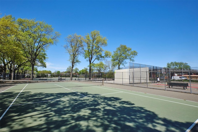 view of tennis court with fence and community basketball court