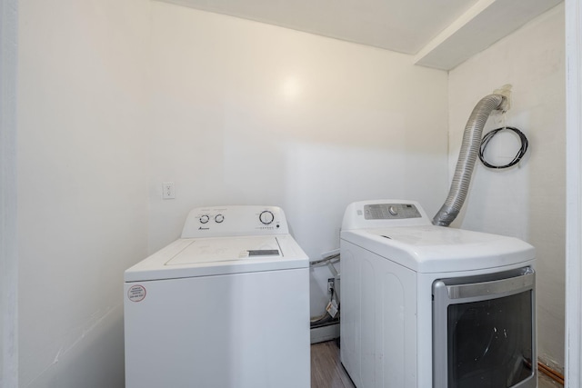 washroom featuring laundry area, washer and dryer, and wood finished floors