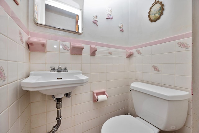 half bathroom featuring tile walls and toilet