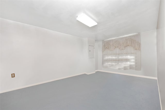 empty room with baseboards and electric panel
