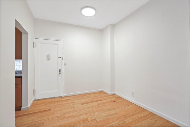 empty room with light wood finished floors and baseboards