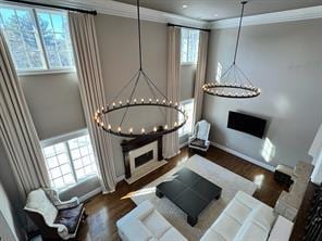 2 Enclave Ct, Dix Hills, NY 11746 - living room with a chandelier, ornamental molding, wood finished floors, and baseboards
