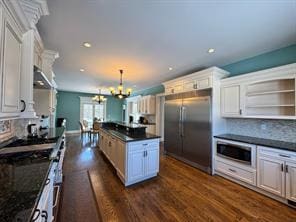 2 Enclave Ct, Dix Hills, NY 11746 - kitchen featuring stainless steel appliances, dark countertops, a chandelier, dark wood-style floors, and decorative backsplash