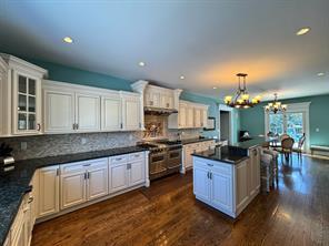 2 Enclave Ct, Dix Hills, NY 11746 - kitchen with dark countertops, a center island, a chandelier, dark wood-style floors, and recessed lighting