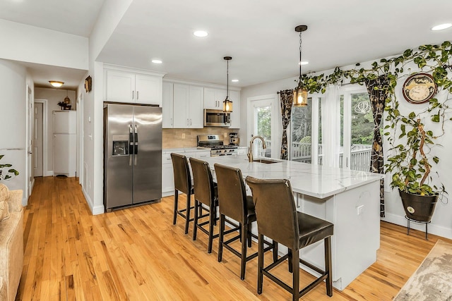 1 Valley Forge Dr, Wheatley Heights, NY 11798 - kitchen with stainless steel appliances, a sink, white cabinetry, light wood-style flooring, and recessed lighting