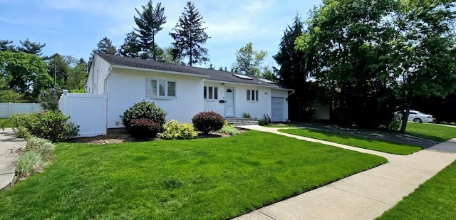 view of front of property featuring fence, an attached garage, a front lawn, and driveway