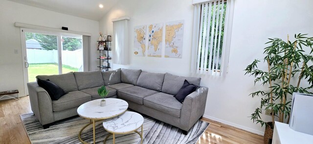 living room featuring baseboards, light wood finished floors, recessed lighting, and vaulted ceiling