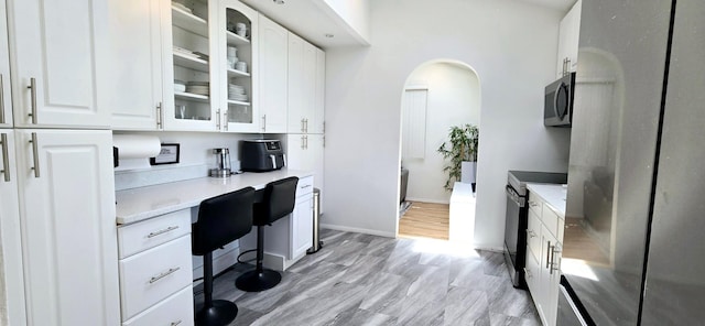 office area with arched walkways and baseboards