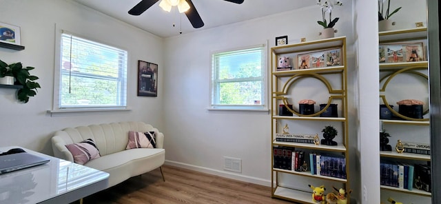sitting room with ceiling fan, visible vents, plenty of natural light, and wood finished floors