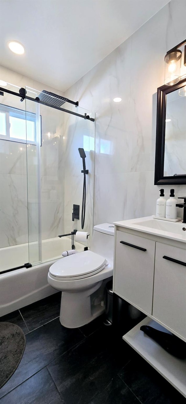 full bathroom featuring toilet, bath / shower combo with glass door, vanity, and tile patterned flooring