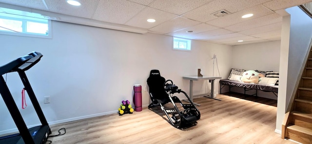 exercise room featuring wood finished floors, visible vents, recessed lighting, a drop ceiling, and baseboards