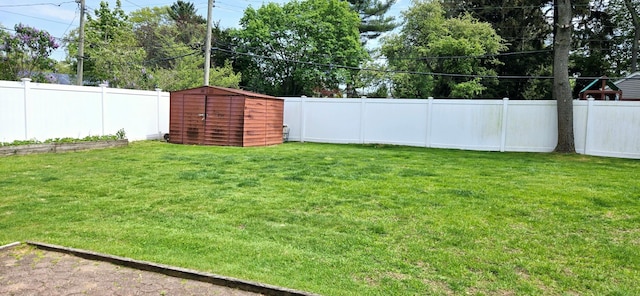 view of yard with an outdoor structure, a storage shed, and a fenced backyard