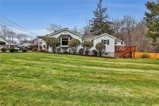 view of front of house with a wooden deck, fence, and a front yard