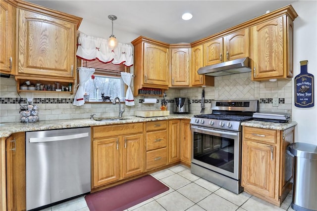 kitchen with a sink, under cabinet range hood, appliances with stainless steel finishes, decorative backsplash, and light tile patterned flooring