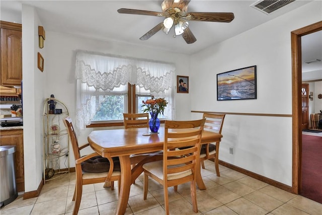 dining room featuring light tile patterned floors, ceiling fan, baseboards, and visible vents
