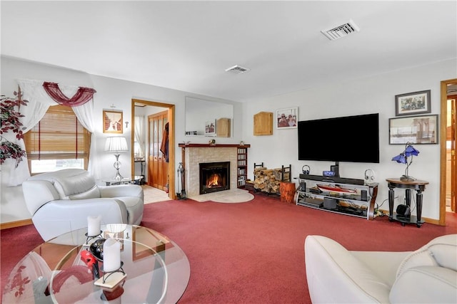 carpeted living room featuring baseboards, a fireplace with flush hearth, and visible vents