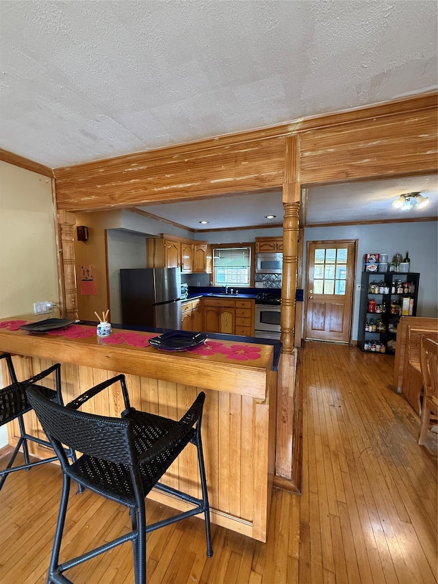 163 E Hawthorne Ave, Valley Stream, NY 11580 - kitchen featuring appliances with stainless steel finishes, a textured ceiling, light wood-type flooring, a sink, and dark countertops