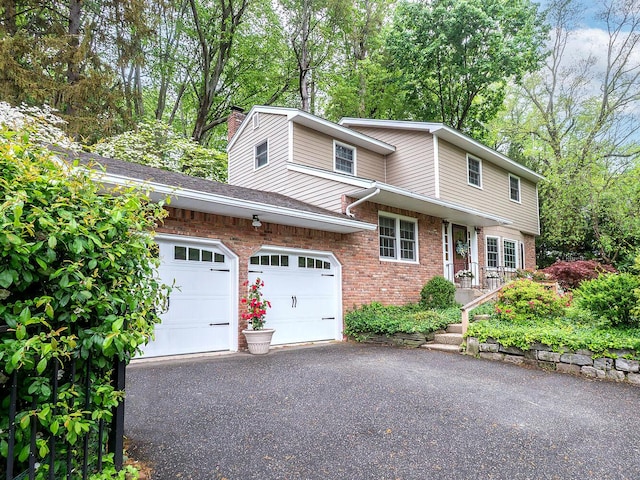 view of front of property featuring aphalt driveway, an attached garage, brick siding, a chimney, and a shingled roof