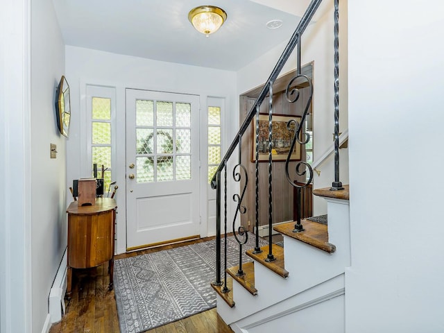 entryway with stairs, a baseboard radiator, and wood finished floors