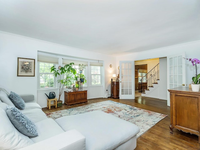 living area featuring french doors, baseboards, ornamental molding, wood finished floors, and stairway