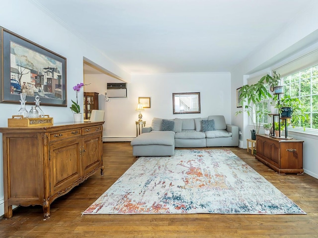 living area featuring baseboard heating, a wall unit AC, and wood finished floors