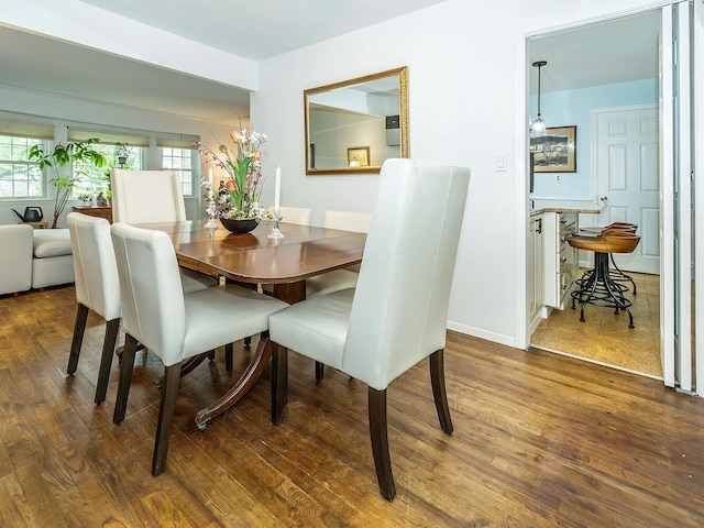 dining space with baseboards, a healthy amount of sunlight, and wood finished floors