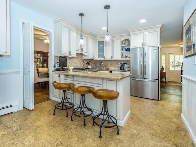 kitchen featuring white cabinetry, a peninsula, stainless steel fridge, and glass insert cabinets