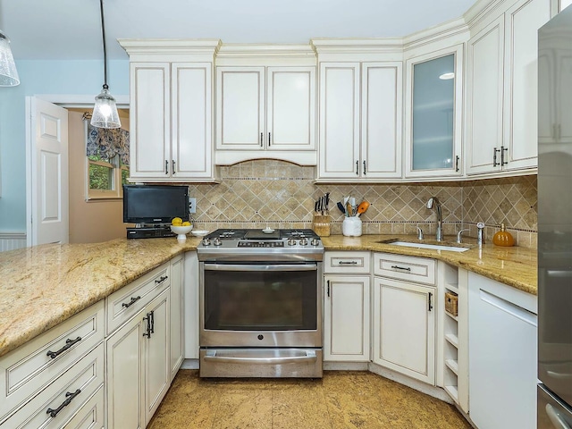 kitchen featuring light stone countertops, pendant lighting, gas stove, a sink, and backsplash