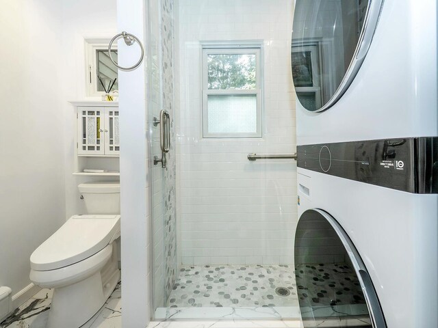bathroom featuring toilet, stacked washer / dryer, and a shower stall