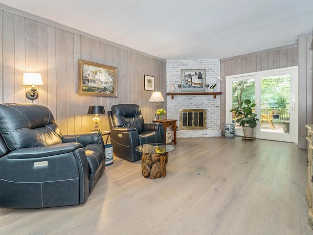 living room featuring wood walls, a brick fireplace, and wood finished floors