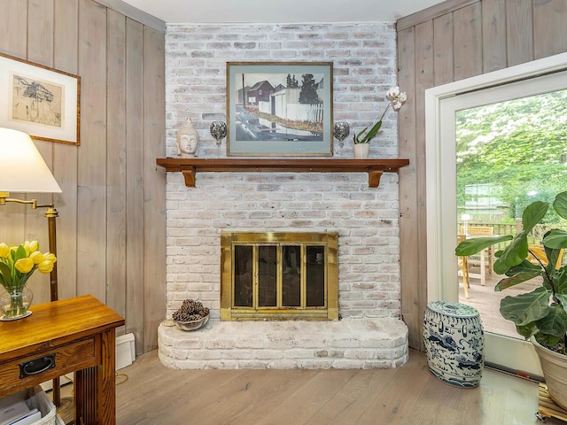 living room with wood walls, a fireplace, and wood-type flooring