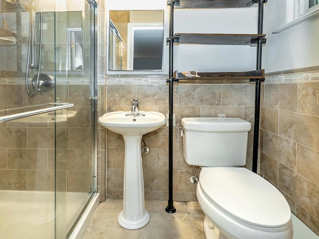 bathroom featuring a shower stall, tile walls, tile patterned flooring, and toilet