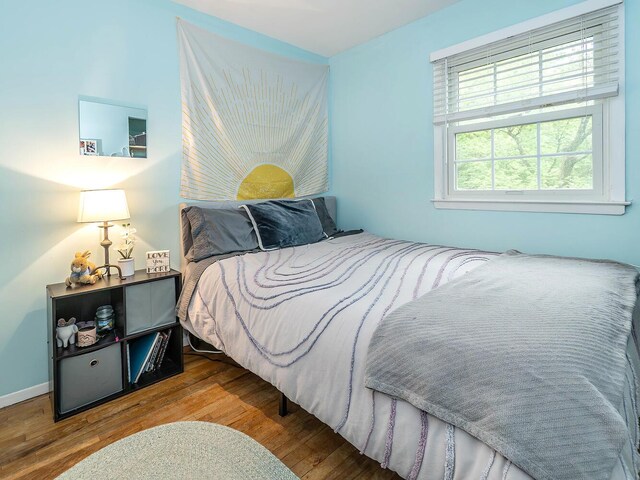 bedroom featuring baseboards and wood finished floors
